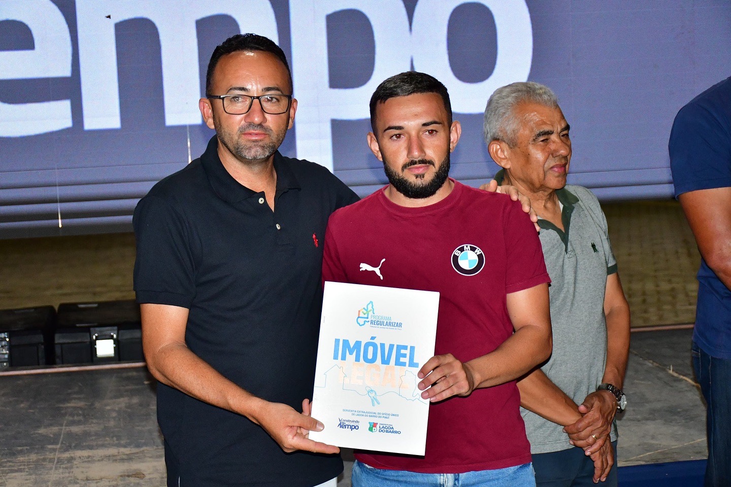 Entrega de título do programa Imóvel Legal a morador beneficiado